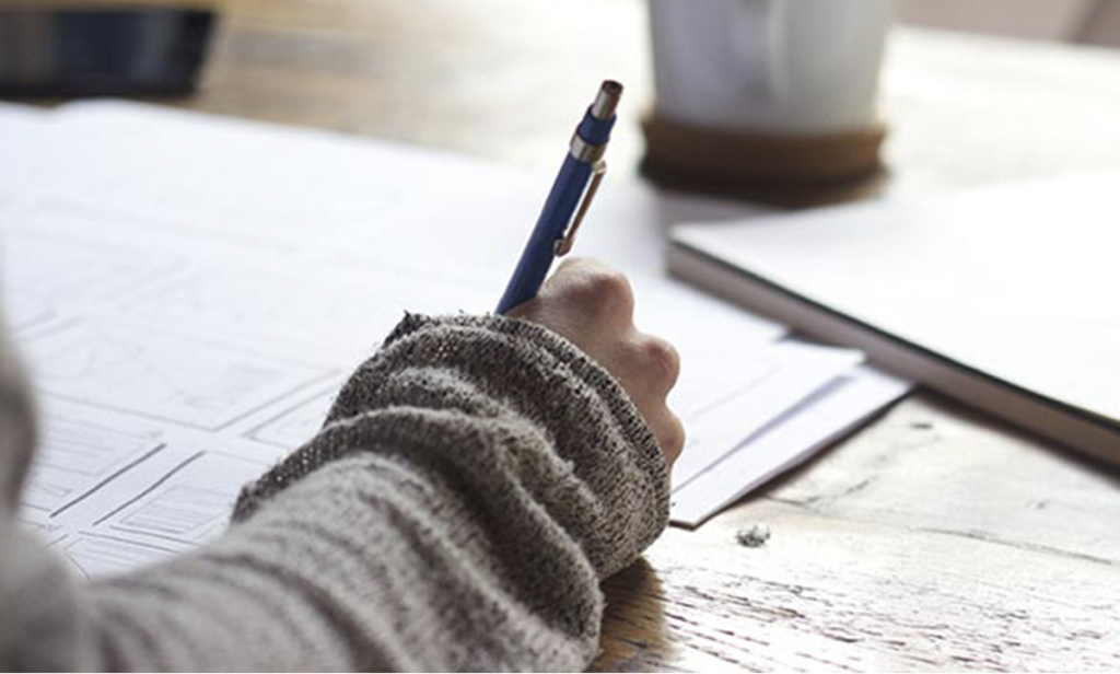 Male hand writing and cup